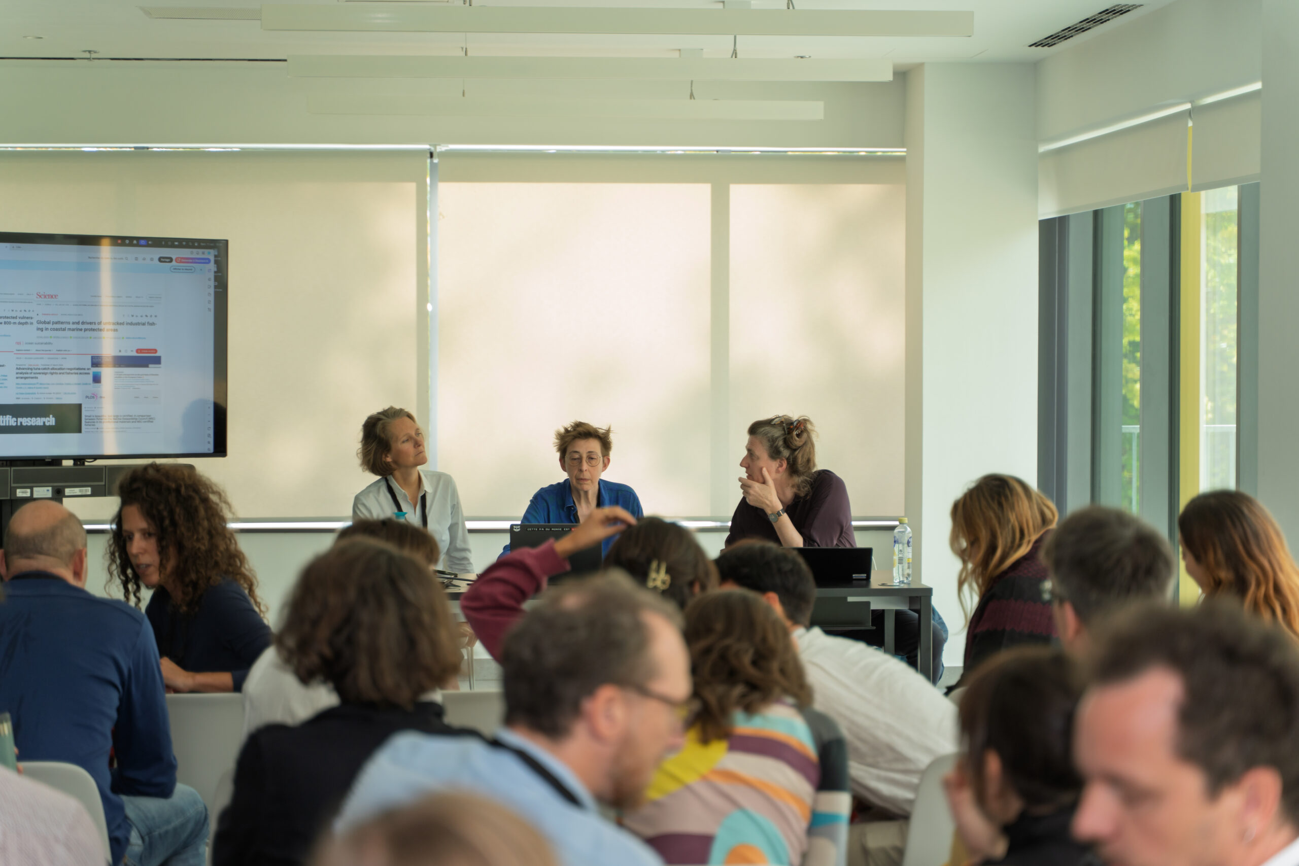 Claire Nouvian, Stéphane Horel and Brigitte Alfter sitting on the panel, preparing to talk to a packed group of journalists, who are talking to each other animatedly.