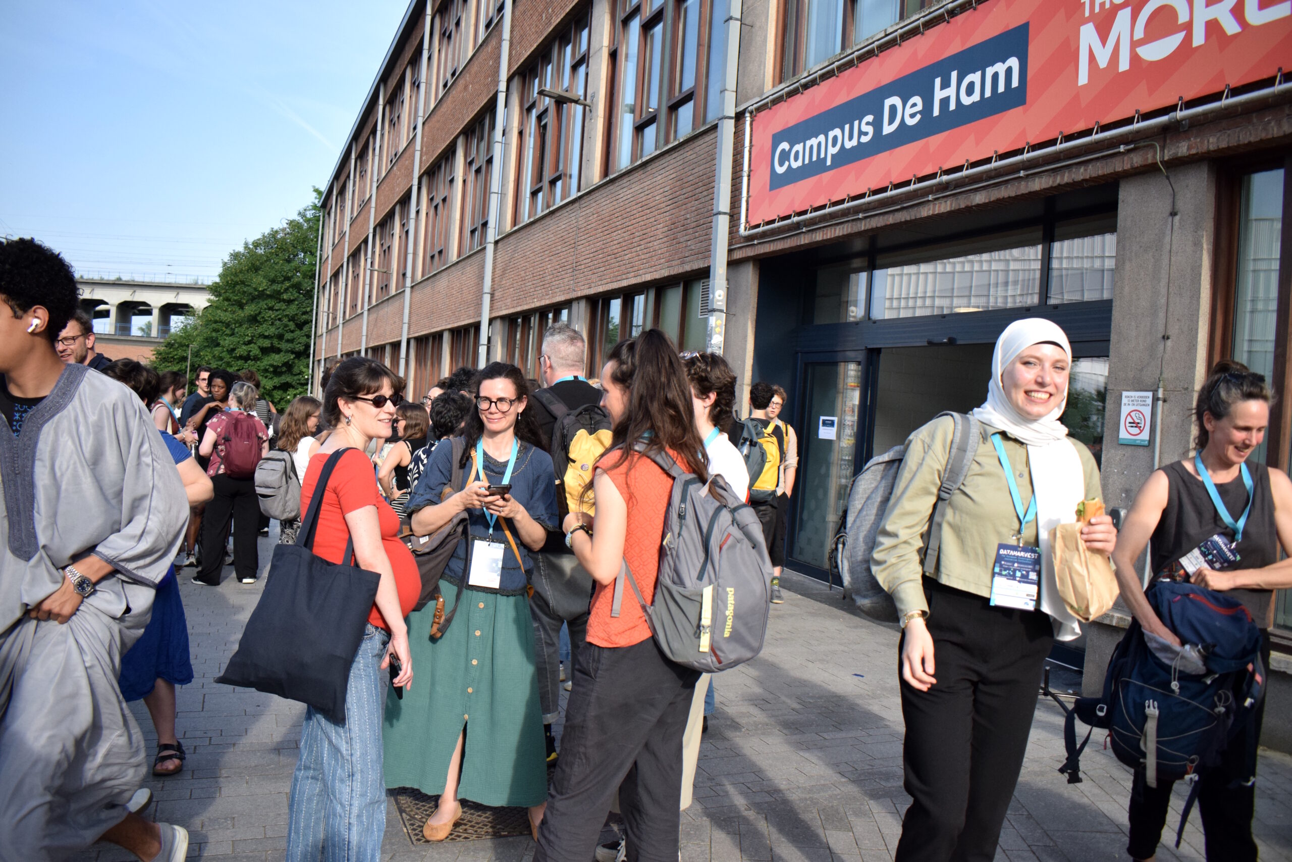A crowd socialises in the sun outside the Dataharvest 2026 conference venue.
